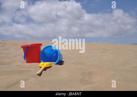 sandstrand, sand,schaufel, eimer, spielzeug, spielen, buddeln, sandspielzeug, urlaub, vergnügen,  rot, gelb, bunt, schippe, eimerchen, blau , sandkasten, spielplatz Stock Photo