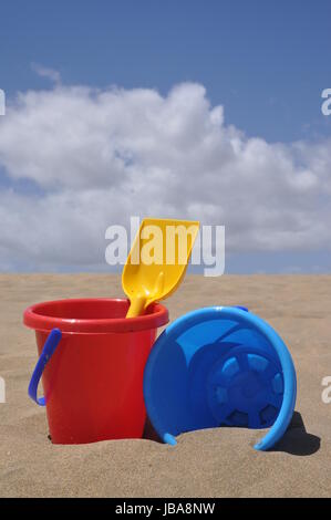 sandstrand, sand,schaufel, eimer, spielzeug, spielen, buddeln, sandspielzeug, urlaub, vergnügen,  rot, gelb, bunt, schippe, eimerchen, blau , sandkasten, spielplatz Stock Photo