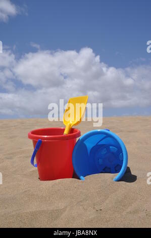 sandstrand, sand,schaufel, eimer, spielzeug, spielen, buddeln, sandspielzeug, urlaub, vergnügen,  rot, gelb, bunt, schippe, eimerchen, blau , sandkasten, spielplatz Stock Photo