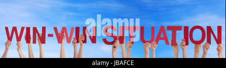 Hands Holding the Words Win-Win Situation in front of the Sky Stock Photo
