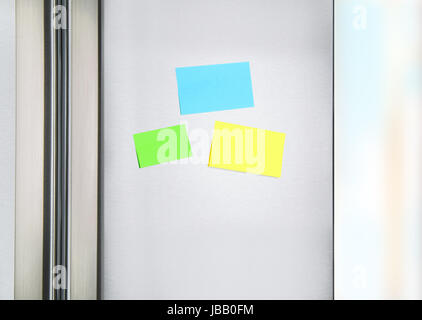 Sticky notes on the fridge, three colorful paper on the door on refrigerator for message, little reminder sheets, communication on the kitchen Stock Photo