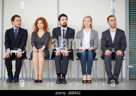 Portrait of several elegant employees sitting on chairs Stock Photo