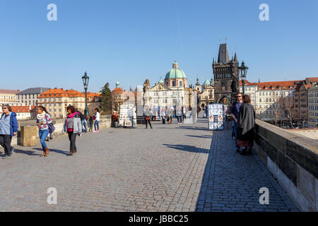 PRAGUE, CZECH REPUBLIC - MARCH 13: Charles Bridge on march 13, 2014 in Prague Czech Republic. Charles Bridge is a popular tourist attraction in Prague. On the bridge you can find many street artists. Stock Photo