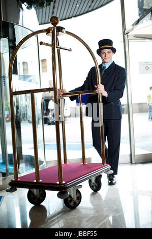 A hotel doorman wearing his full uniform at a 5-star hotel, greets all ...