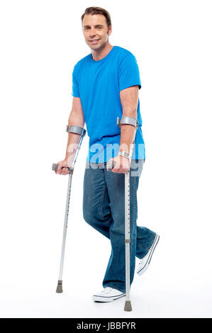 Young man with crutches trying to walk. Accidental case Stock Photo