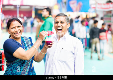 2 Indian Senior Couple Eating Fair In Suraj kund Stock Photo
