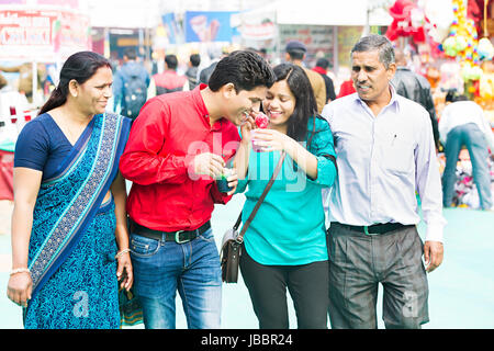 happy Indian Family Eating Ice Candy Sister Feeding On Brother Fair In Suraj kund Stock Photo