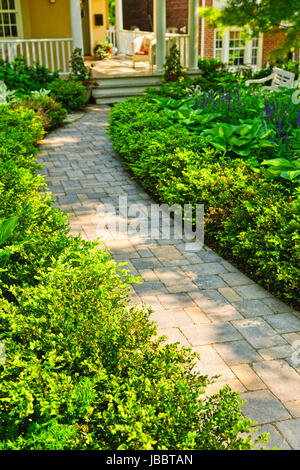 Paved stone path in lush green home garden Stock Photo