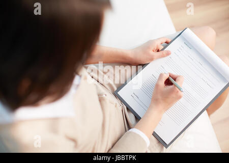 Female counselor writing down some information about her patient Stock Photo