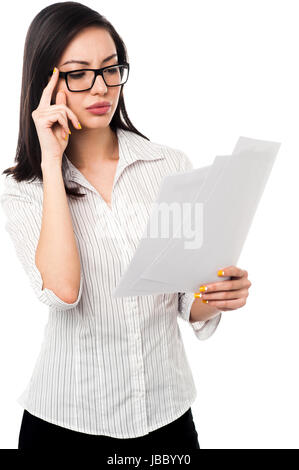 Successful young businesswoman reading annual reports Stock Photo