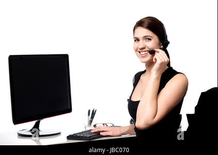 Pretty female support staff attending clients queries. Stock Photo