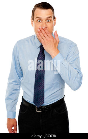 Surprised businessman with hand on mouth, expressing amazement Stock Photo