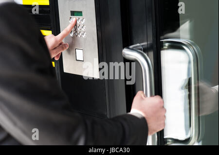 Businessman entering safe code to unlock the door. Stock Photo
