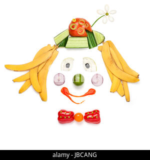 A creative food concept demonstrating a portrait of smiling clown made of vegetables and fruits in a menu for children. Stock Photo