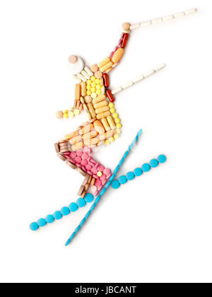 Doping pills and drugs in the shape of a winter jumping skier. Stock Photo