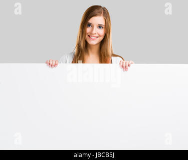 Young and beautiful woman holding a big blank board, isolated over white background Stock Photo