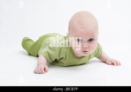 crawling baby in green romper suit isolated on white background. studio shot Stock Photo