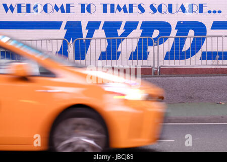 New York City, USA. 3rd May, 2017. A yellow taxi passes an NYPD (New York Police Department) logo at Times Square in New York City, USA, 3 May 2017. - NO WIRE SERVICE - Photo: Kevin Kurek/dpa/Alamy Live News Stock Photo