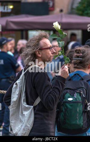 Warsaw, Poland - June 10th, 2017: Anti-government demonstrator rise a white rose during the 86th monthly anniversary of the Smolensk crash in April 2010. Stock Photo