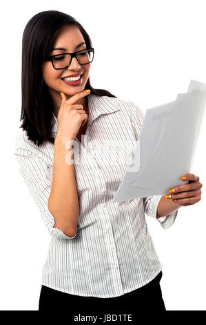 Successful young businesswoman reading annual reports Stock Photo