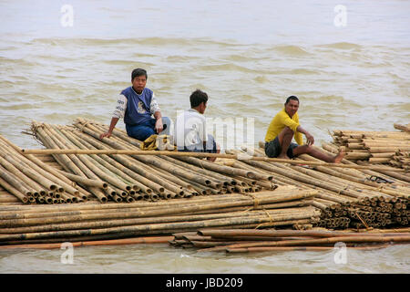 Local men floating on a bamboo raft down Ayeyarwady river near Mandalay, Myanmar. Ayeyarwady river is the largest river in Myanmar.