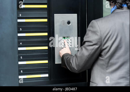 Businessman entering safe code to unlock the door Stock Photo