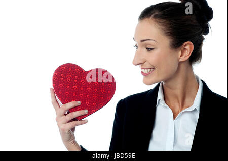 Beautiful office lady holding heart shaped gift Stock Photo