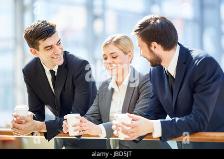 Happy employees with drinks spending cofee break together Stock Photo
