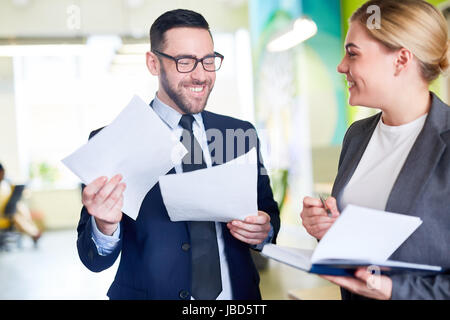 Happy employer and young manager discussing papers Stock Photo