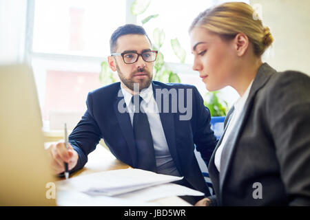 Boss talking to one of employees at meeting Stock Photo
