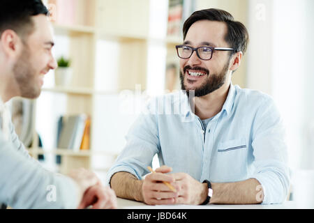 Happy young specialists discussing ideas Stock Photo