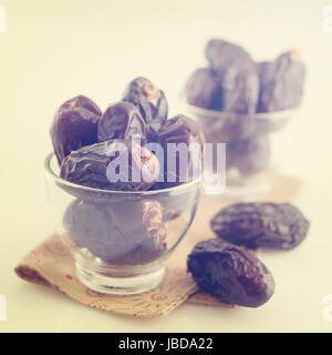 Dried date palm fruits or kurma, ramadan food which eaten in fasting month in vintage retro effect. Stock Photo