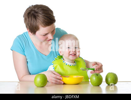 mother feeding kid boy with spoon isolated on white Stock Photo