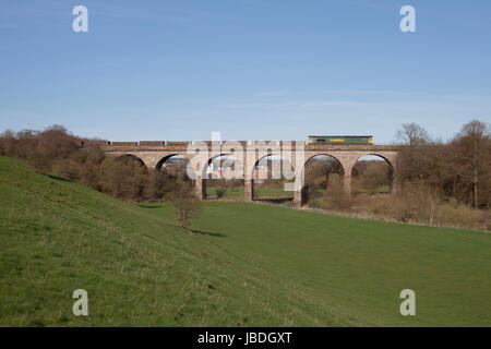 Freightliner Class 66  locomotive crosses Hurlford viaduct south of Kilmarnock (Scotland) with a train from a Network Rail track renewal site Stock Photo