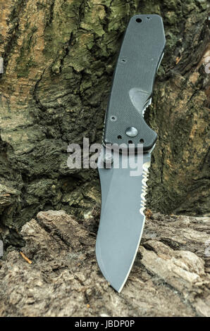 Tactical knife with a serritorial blade. Pocket knife. Stock Photo