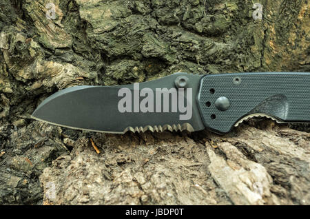 Kind of a tactical knife blade. Tactical knife with a serritorial blade. Stock Photo