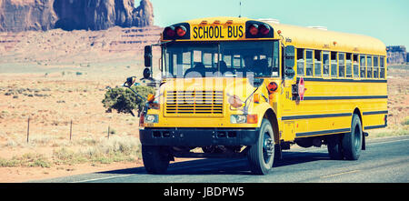 school bus traveling near Monument Valley Stock Photo