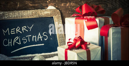 Merry Christmas on a slate with gifts. Stock Photo