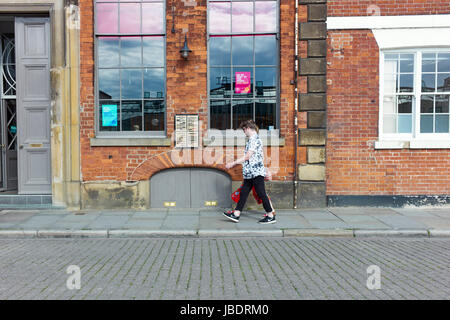 A couple walk past a bar in Princes Dock Street, Hull Stock Photo