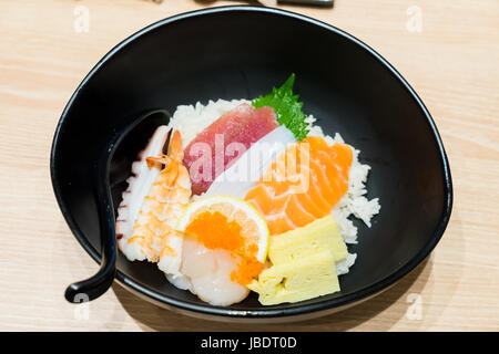 Chirashi Sushi bowl with salmon, tuna, shrimp, scallops, sea bass, sweet omelette served with Wasabi Stock Photo