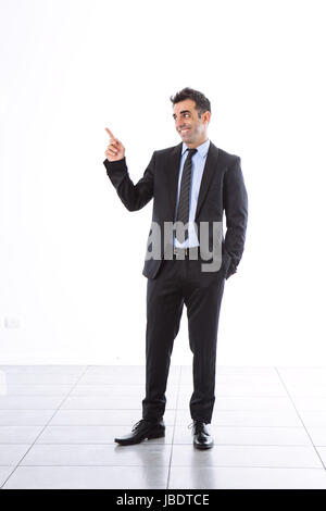A 35 - 40 years with suit office man smiling cool modern look pointing finger side studio shot over a white background full shot Stock Photo