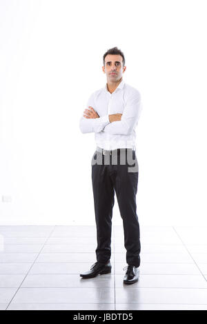 A 35 - 40 years formal without blazer office man dark hair cool modern look arms folded studio shot over a white background full shot Stock Photo