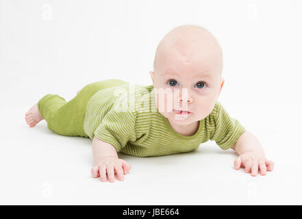 crawling baby in green romper suit isolated on white background. studio shot Stock Photo