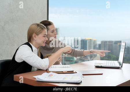 Caucasian business women working together at the office on a laptop computer. Business partnership people concept. Stock Photo