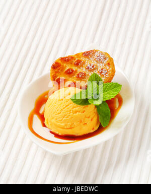 Small Dutch oval-shaped cake (Roomboter kano) with ice cream and caramel syrup Stock Photo