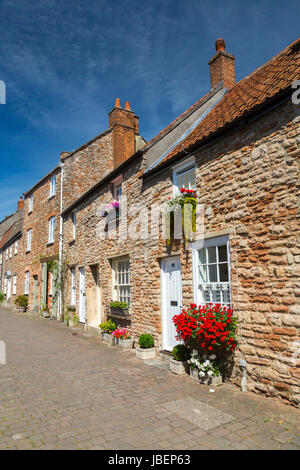 Union Street has a terrace of original stone houses and cottages with attractive floral decorations in Wells, Somerset, England, UK Stock Photo