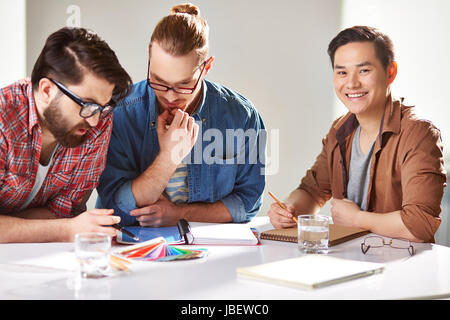 Friendly guys choosing colors from palette Stock Photo