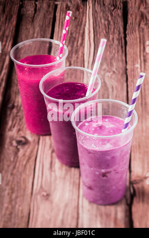 Variety of delicious berry smoothies with strawberry and blueberry blended with low fat yogurt for a healthy summer drink, high angle view standing in a diagonal row Stock Photo
