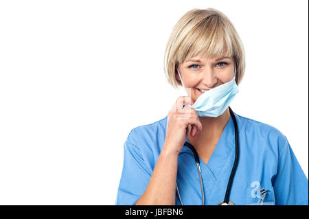 Experienced lady doctor removing her surgical mask Stock Photo