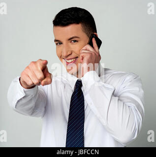 Businessman communicating through mobile and pointing you Stock Photo